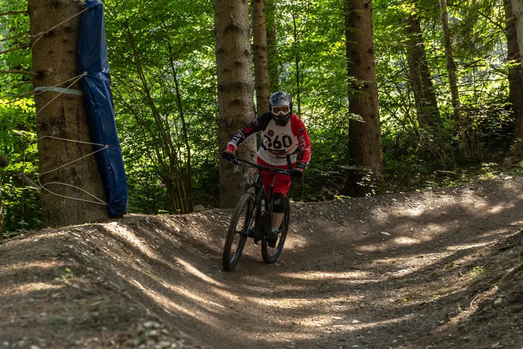 Rider percorre il trail Bad Bunny del Bike Arena Ravascletto, percorso blu immerso nei boschi del Monte Zoncolan.